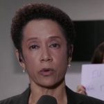 Mulher segura cartaz de protesto durante link ao vivo na Globo (Foto: Reprodução)