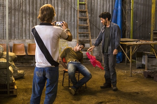 Maria (Alice Wegmann) e Simplício (Lee Taylor) torturam Hermano (Gabriel Leone) e gravam um vídeo (Foto: Globo/Marília Cabral)