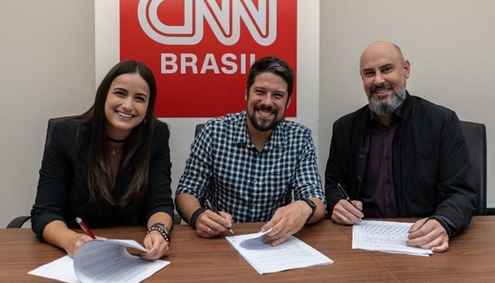 Mari Palma e Phelipe Siani assinam contrato com a CNN Brasil ao lado de Douglas Tavolaro, CEO do canal (Foto: Divulgação/CNN Brasil)