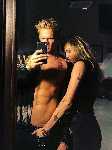Miley Cyrus posa ao lado de Cody Simpson com mão boba (Foto: Reprodução)