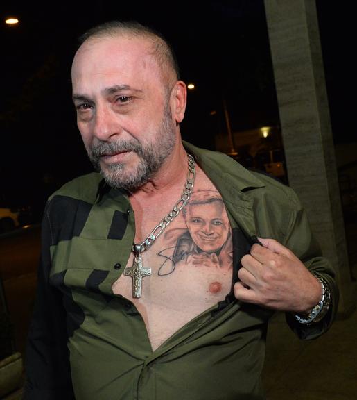 Amigo de Gugu, o diretor Goiabinha, exibe tatuagem do apresentador na missa do sétimo dia (Foto: Reprodução)