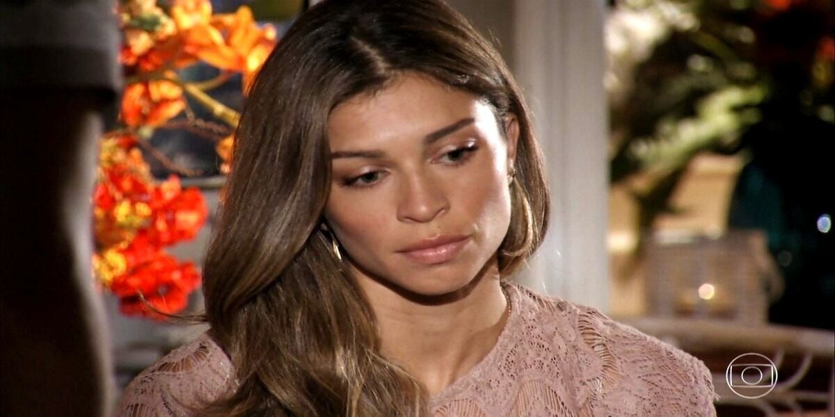 Ester está triste de cabeça abaixada em cena de Flor do Caribe