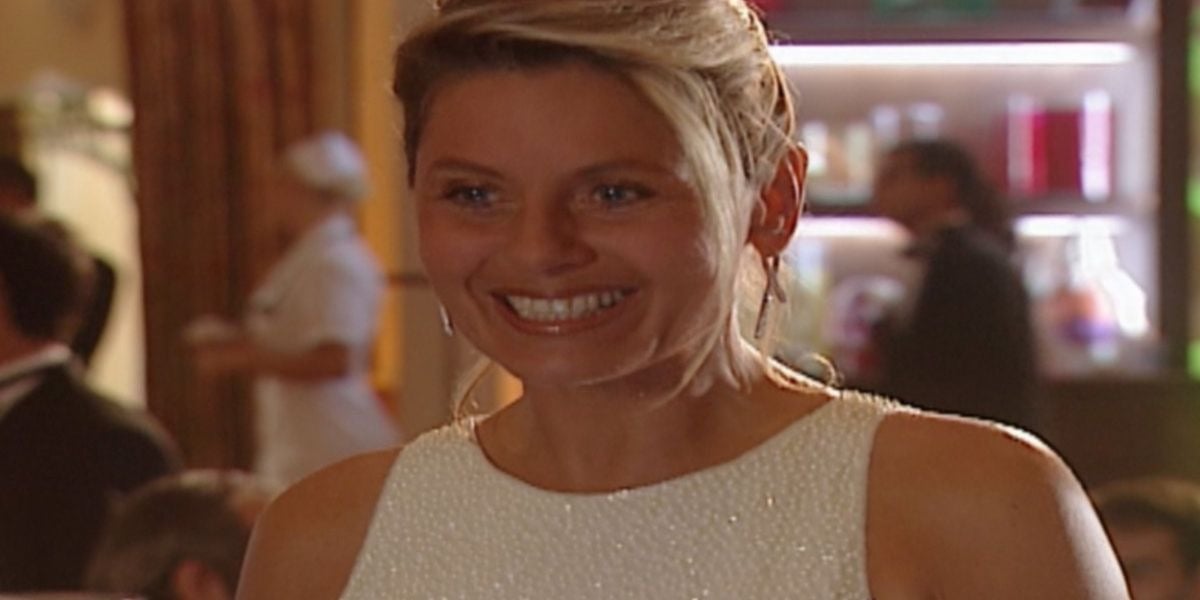 Helena de Laços de Família está sorridente usando um vestido brilhoso sem mangas em cena da novela do Vale a Pena Ver de Novo