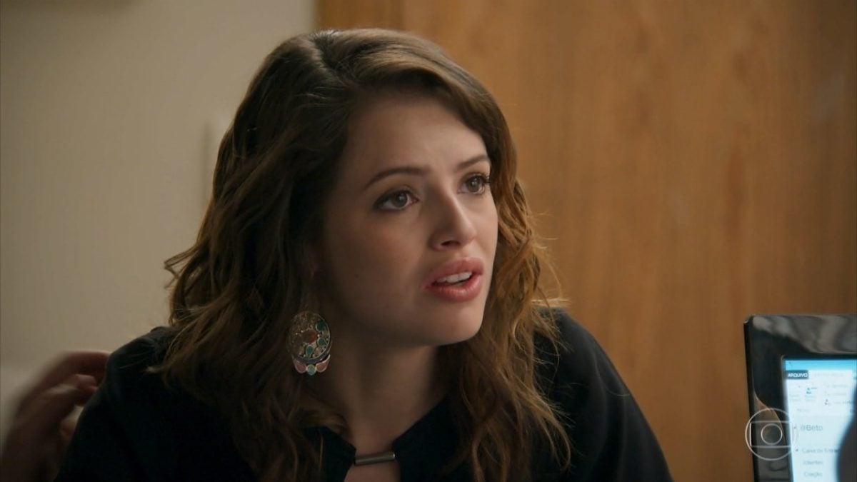 Camila em novela haja Coração com expressão confusa, ela é mulher branca, de cabelos castanhos escuros