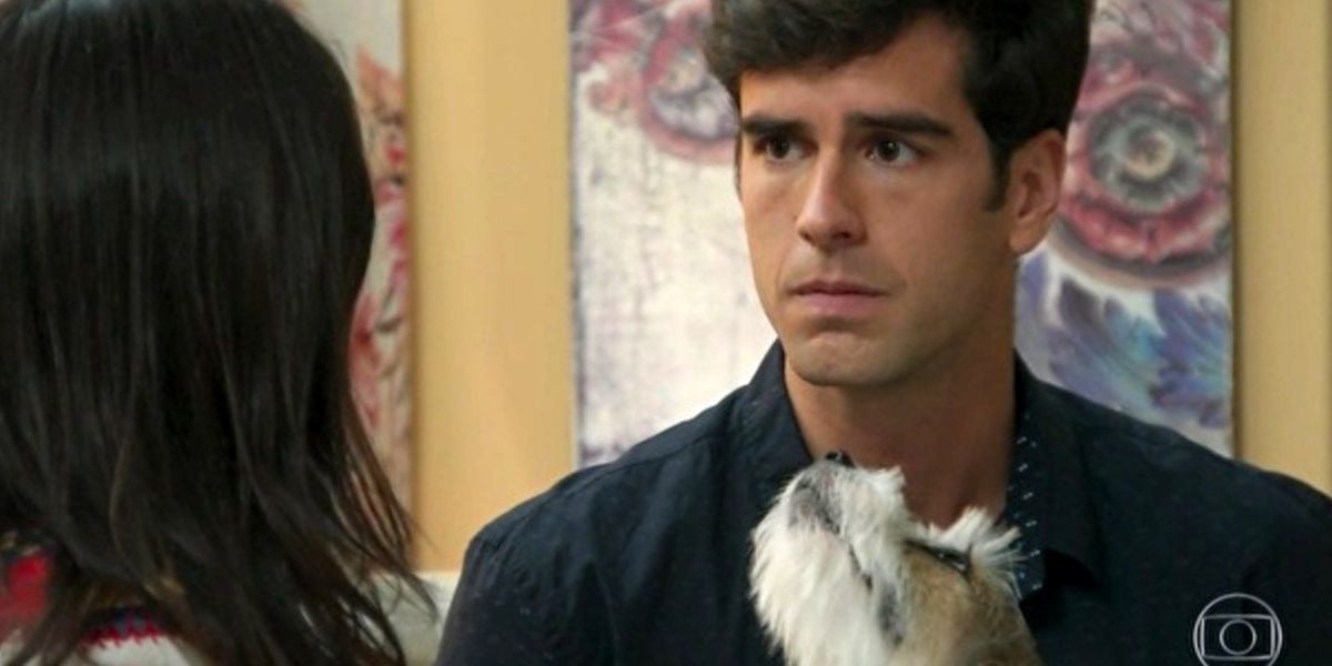 Felipe em cena de Haja Coração segurando cachorrinho