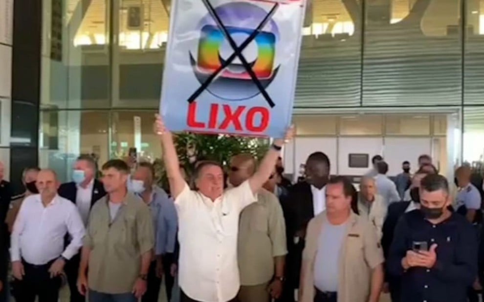 Bolsonaro surta, destila ódio à Globo e levanta cartaz absurdo em público: "Globo Lixo"
