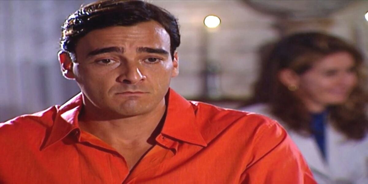 Danilo é homem que usa camisa social laranja, branco que tem cabelo curto e liso na trama de Laços de Família