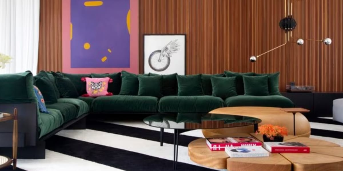 Sofá confortável da sala de estar da residência com paredes de madeira (Reprodução: instagram)