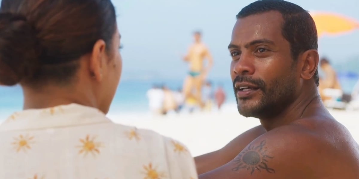 Ben e Jenifer conversam sentados na areia da praia