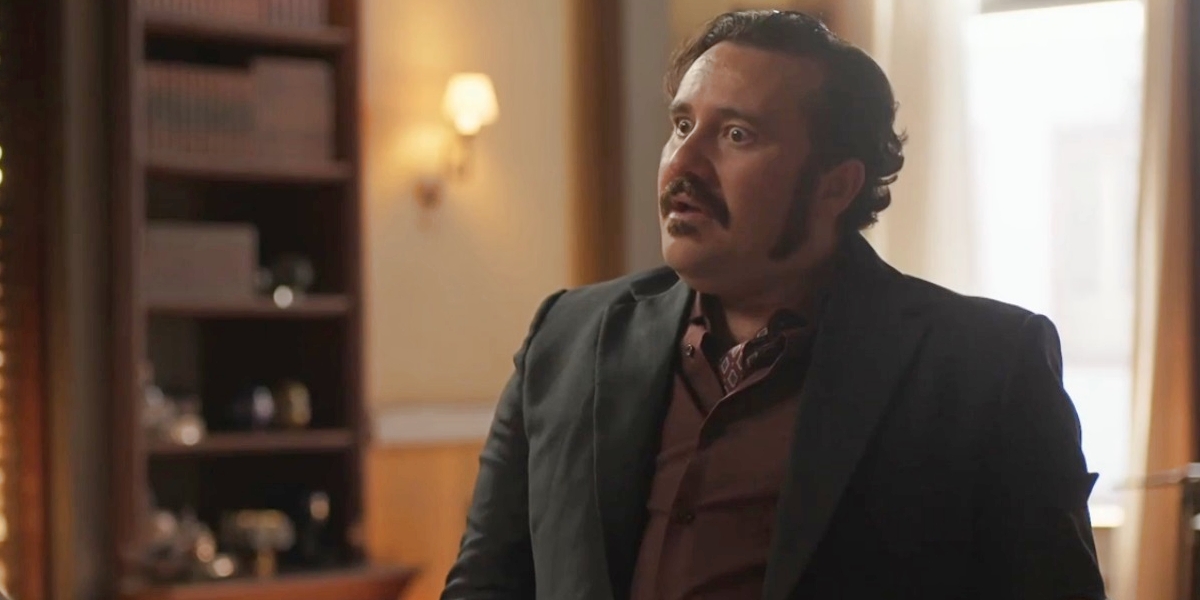 Vespertino é um homem que usa terno preto, camisa social cor de vinho, costeleta e bigode além de cabelos pretos em cena da novela Mar do Sertão
