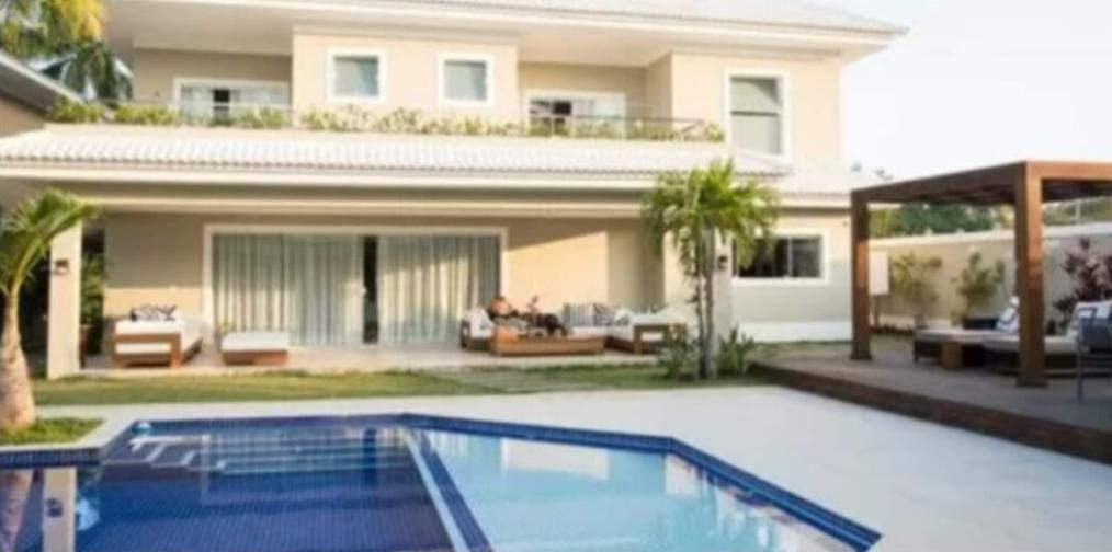 Piscina absurda com muita área de lazer e rodeada por verde (Reprodução: Youtube)