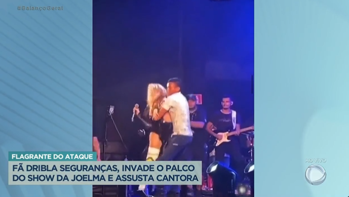 Joelma sendo agarrada por fã no palco (Foto Reprodução/PlayPlus)