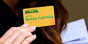 Mulher segurando cartão do Bolsa Família - Foto Reprodução Internet