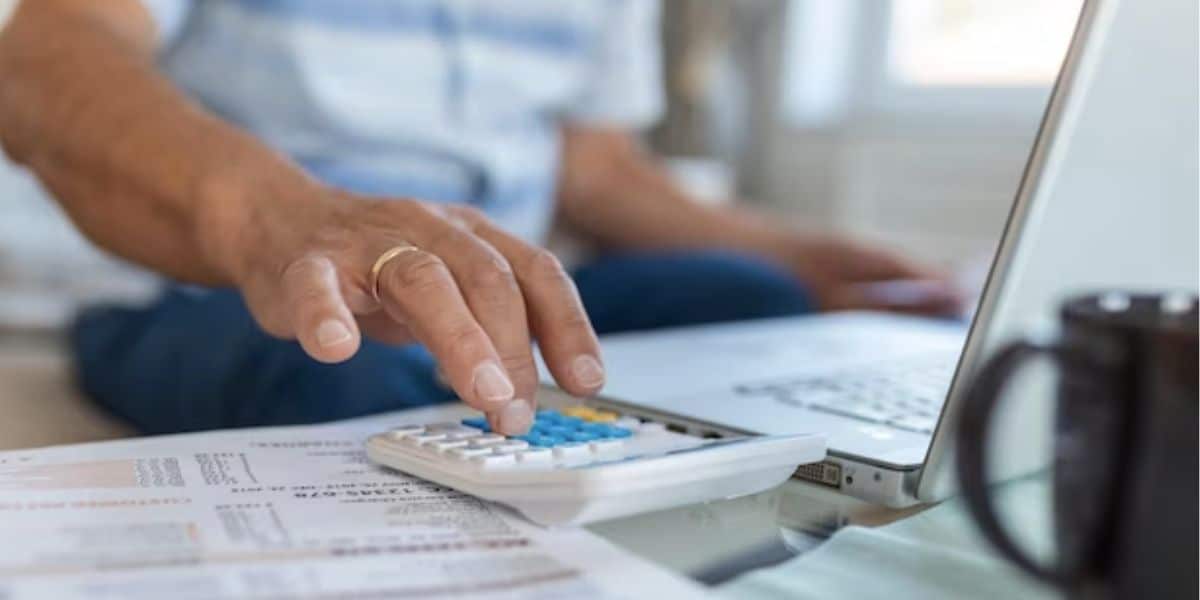 Pessoa fazendo conta de dívidas (Foto: Reprodução / Freepik)