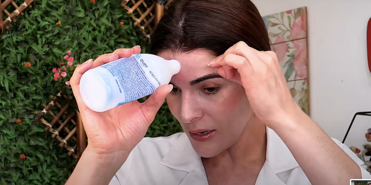 Patrícia Ellias com frasco em sua testa (Foto: Reprodução / YouTube)
