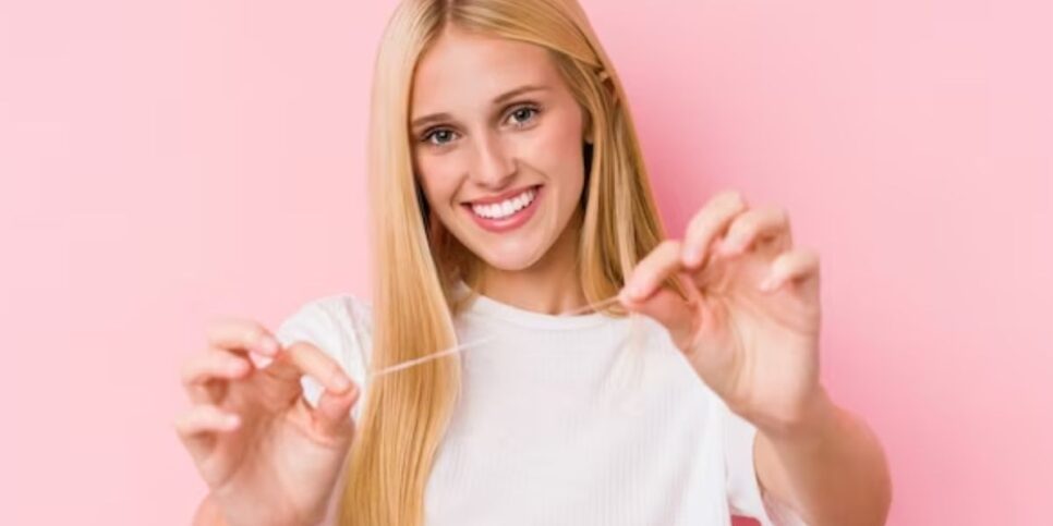 Mulher segurando fio dental (Foto: Reprodução / Freepik)