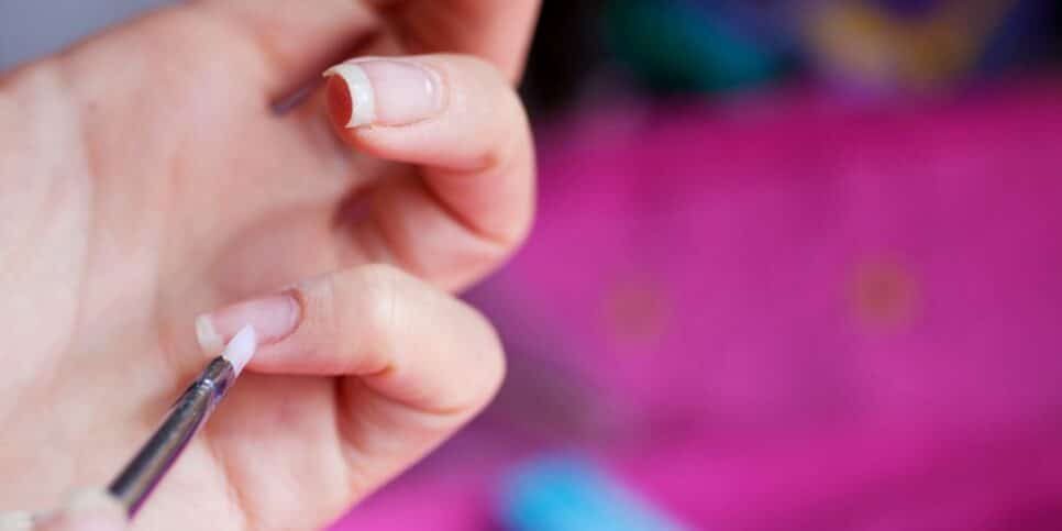 Mulher cuidando da unha (Foto: Canva) 