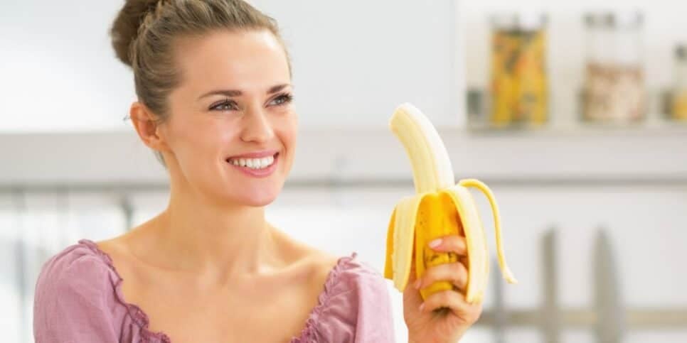 Mulher comendo banana (Foto: Canva) 