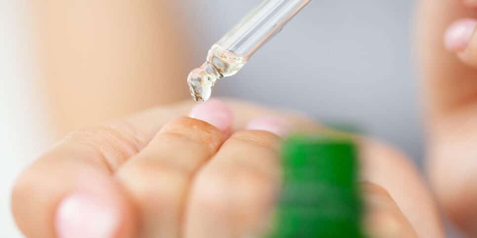 Mulher hidratando unhas (Foto: Canva)