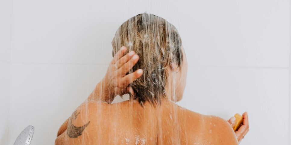 Mulher lavando o cabelo (Foto: Canva)
