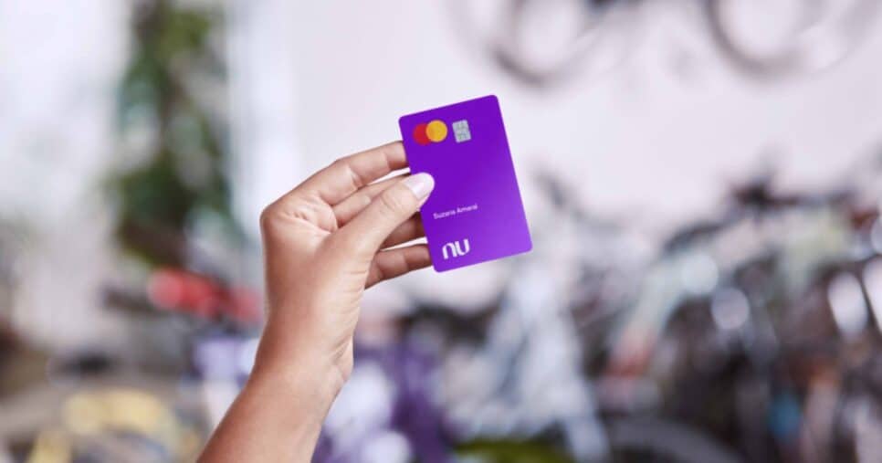 Mulher segurando cartão de crédito do Nubank (Foto: Reprodução / site oficial fintech)