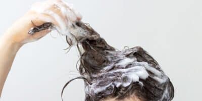 Mulher lavando o cabelo com shampoo  (Reprodução: Canva)