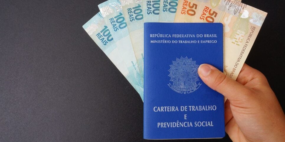 Carteira de trabalho e notas de real (Foto: Canva)