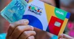 Mulher segurando notas de cem reais e cartão do Bolsa Família (Foto: Site do PT)