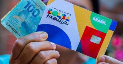 Mulher segurando notas de cem reais e cartão do Bolsa Família (Foto: Site do PT)
