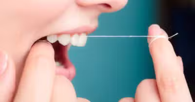 Pessoa passando fio dental no dente (Foto: Divulgação)