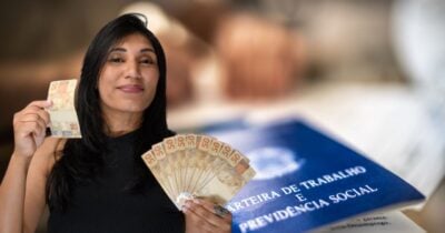 Mulher segurando notas de cem reais e carteira de trabalho (Fotos: Reproduções / Freepik / Canva)