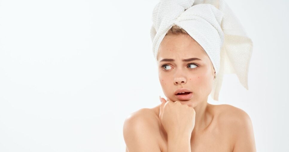 Mulher com toalha na cabeça (Foto: Canva)