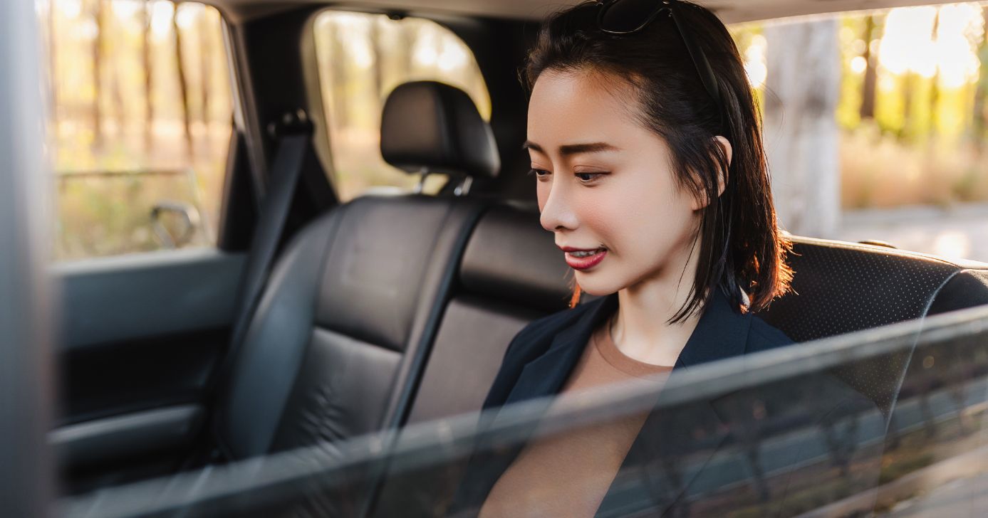 Mulher no banco traseiro (Foto: Canva)