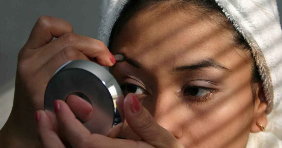 Mulher se maquiando (Foto: Canva)