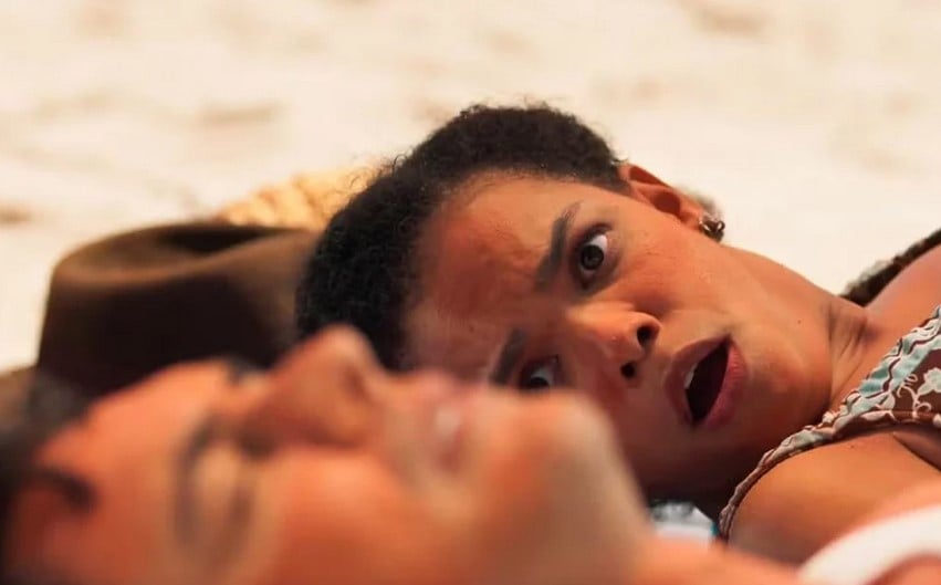 Candinho (Sergio Guizé) e Dita (Jeniffer Nascimento) em cena de Êta Mundo Melhor! na praia (Foto: Reprodução / Globo)