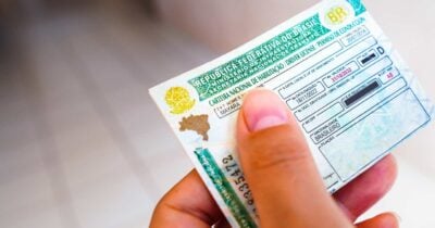 Pessoa segurando a CNH (Foto: Canva)