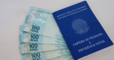 Notas de cem reais e carteira de trabalho (Foto: Canva)